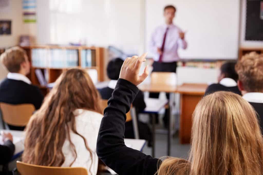 Student Raising Hand To Ask Question In Classroom
